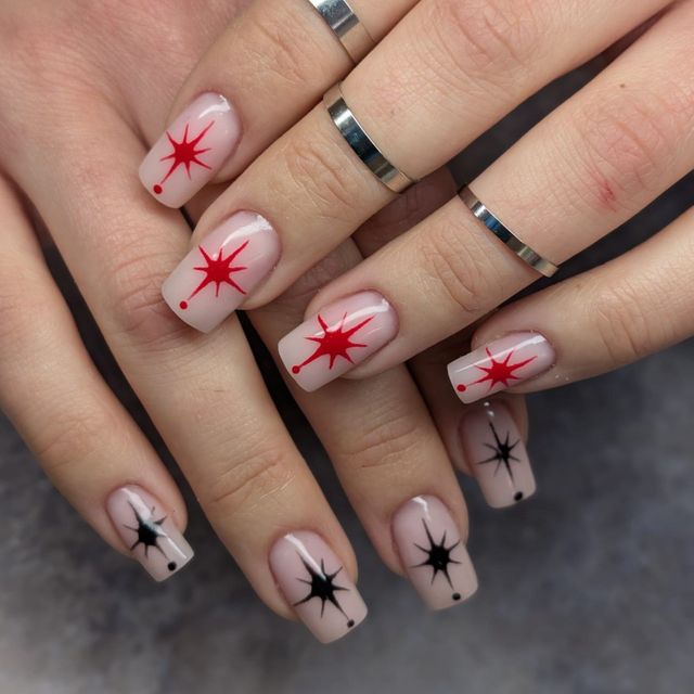 Manicure z graficznym zdobieniem w gwiazdki czerwone i czarne
